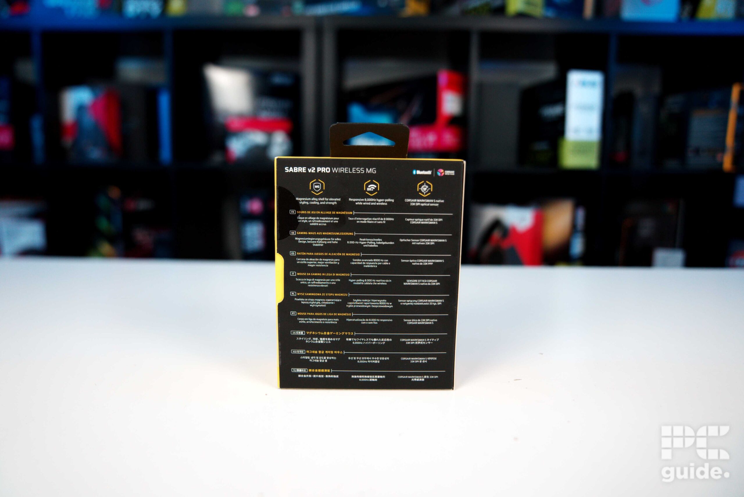 The back of the Corsair Sabre v2 PRO Wireless MG box with text, sitting on a white table.