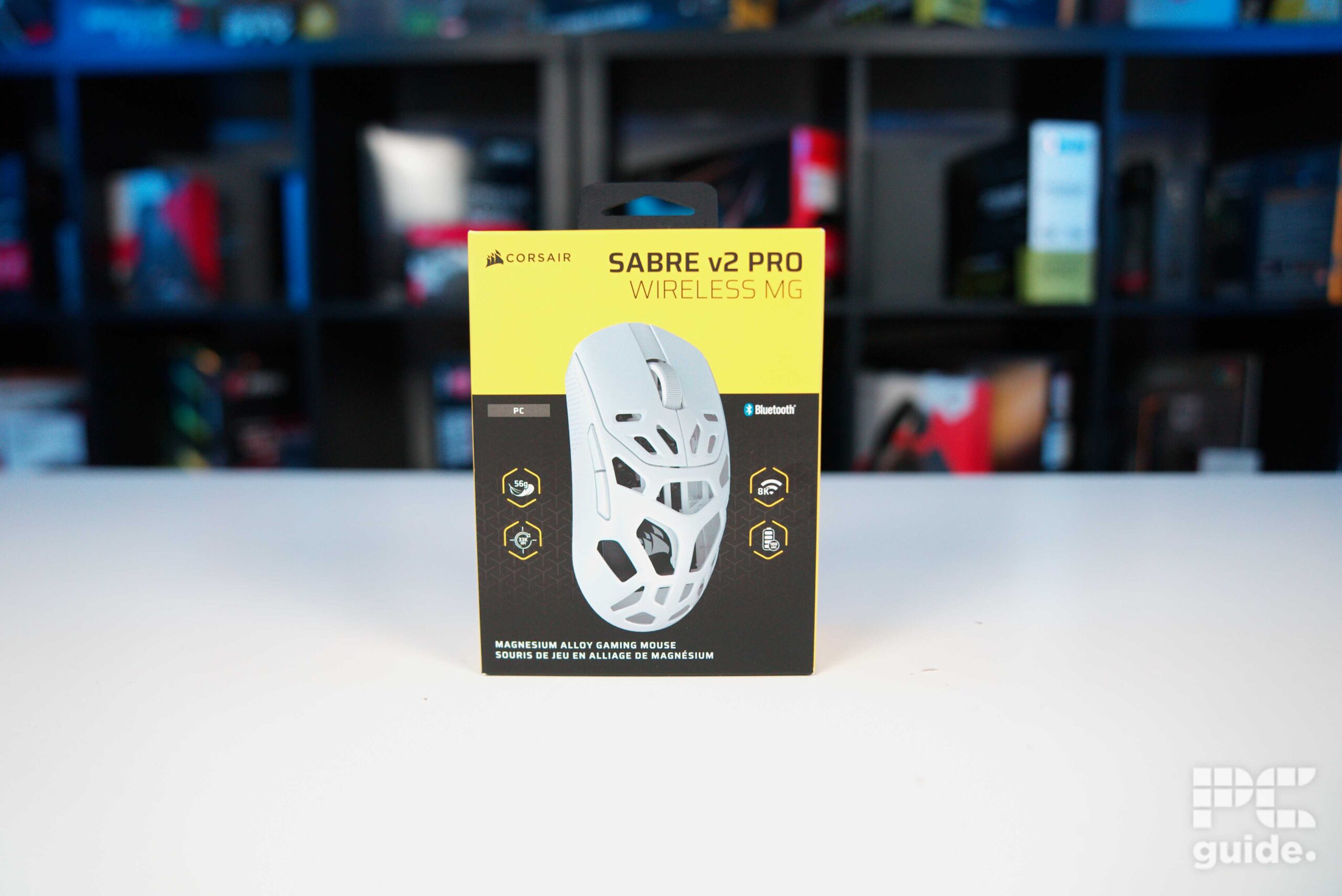 A front on look at the white Corsair Sabre v2 PRO Wireless MG on the front with yellow and black background with the specifics.