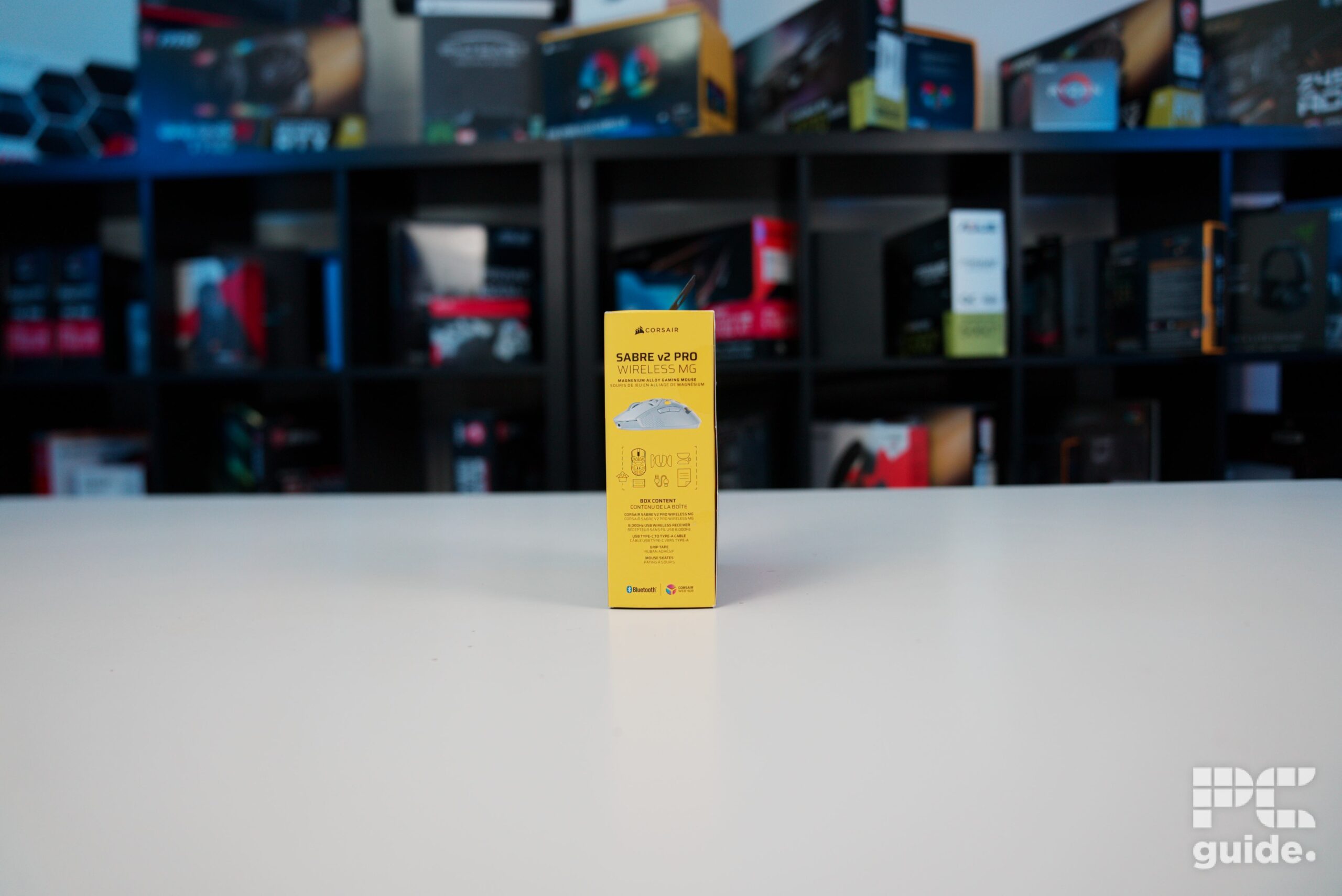 A look at the side of the product box of the Corsair Sabre v2 PRO Wireless MG sitting on a white table.